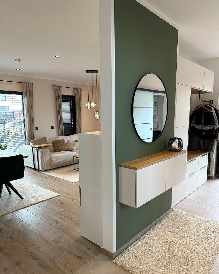 White floating ikea besta bench hack with natural wood top and round mirror in modern hallway from @cozynized. Clean, organized interior design.