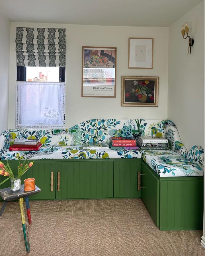Green painted ikea besta bench hack with floral cushions in cozy corner living room by @lotte_studio modern and inviting seating area with storage underneath.