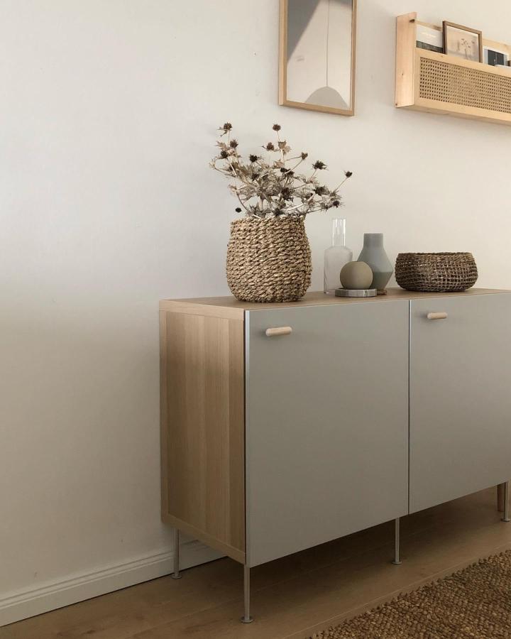 Natural wood and matte gray Ikea Besta sideboard hacks with woven baskets and minimalist decor by @wohngoldstueck.