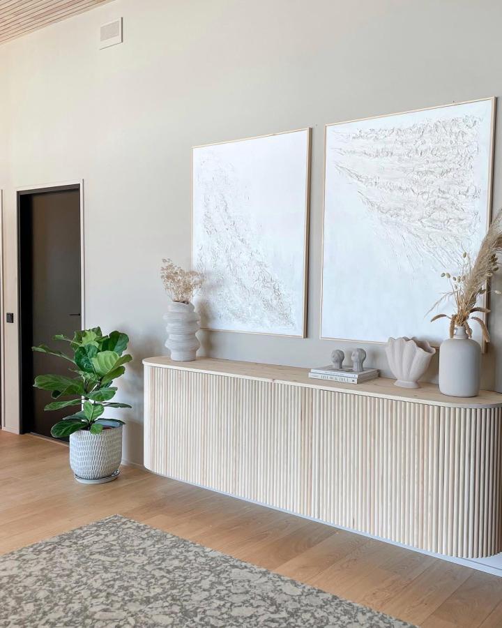 Natural wood slat front Ikea Besta sideboard hack in a minimalist room with neutral décor from @linda__lydia. Modern curved edges detail.