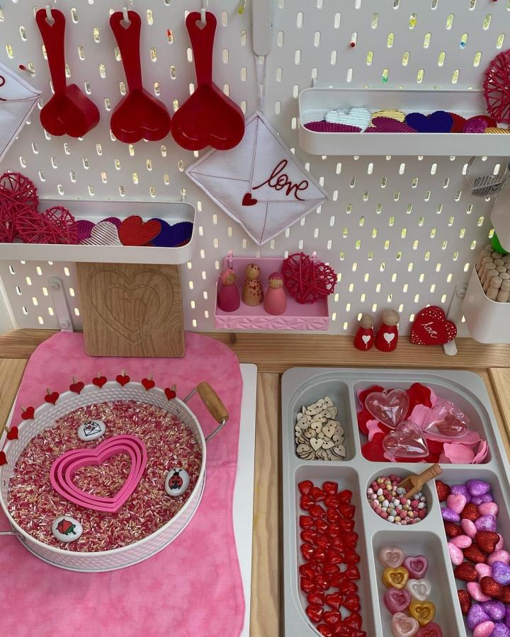 Pink and red heart-themed sensory table setup with wooden accents from @jenniedancer81 featuring ikea flisat sensory table ideas and playful textures.