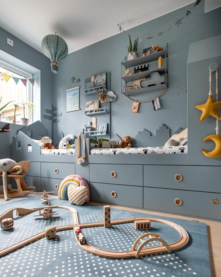Blue built-in storage bench with playful town silhouette and cozy cushions from @playful_rooms. Clever ikea platsa wardrobe hacks for kids' rooms.