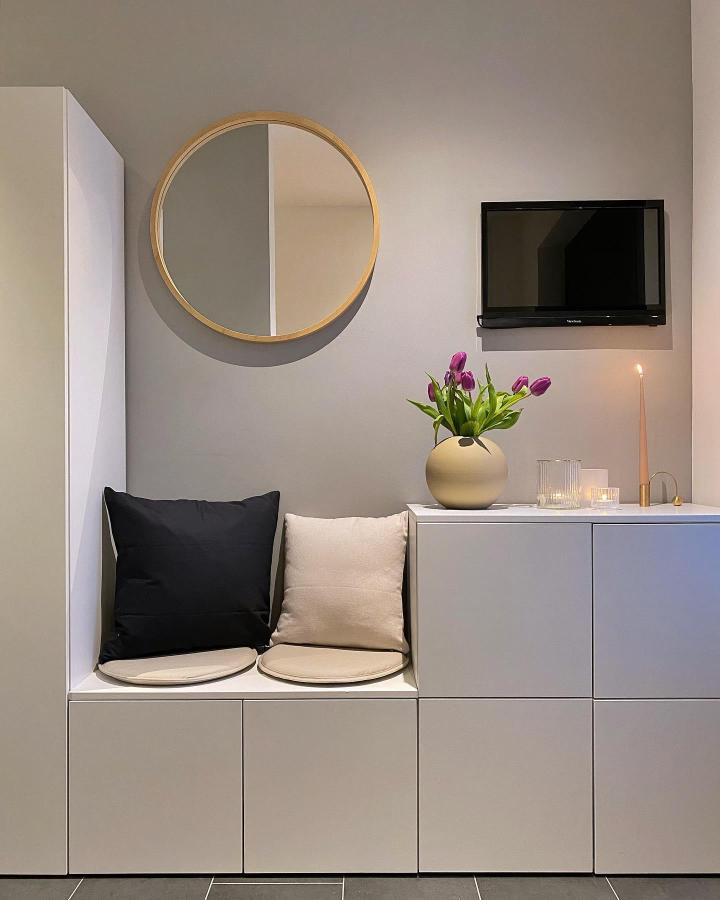 White minimalist seating bench made from ikea platsa wardrobe hacks by @janina_mirjam with round cushions and wooden mirror on wall