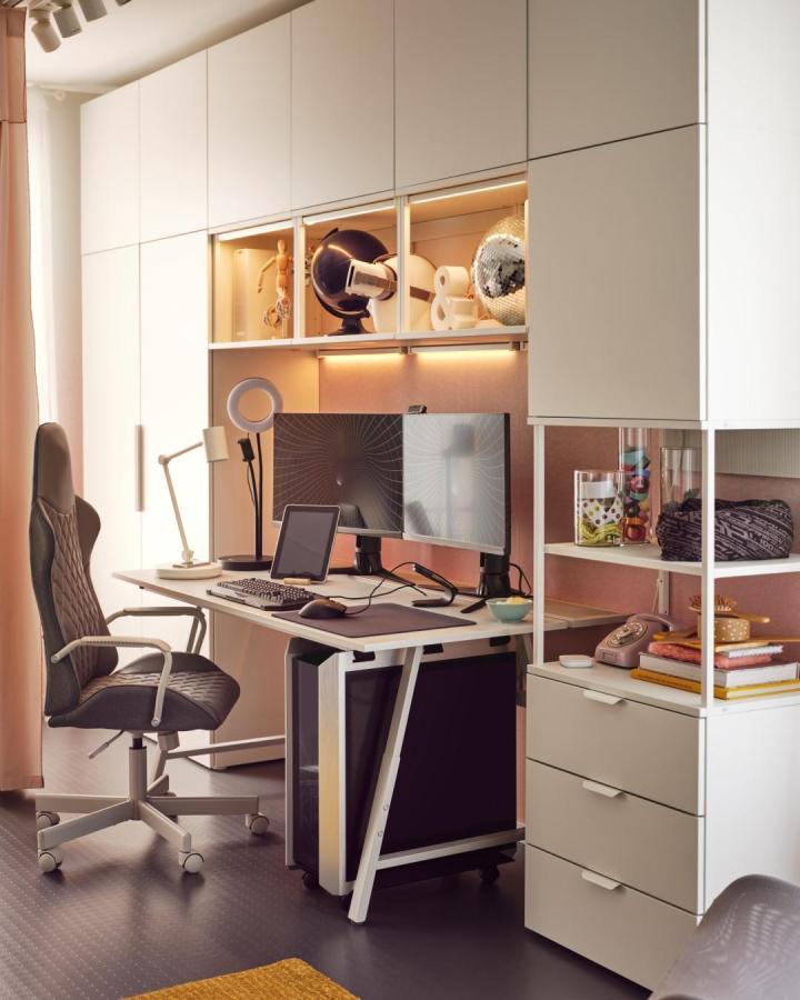 White matte Ikea Platsa wardrobe with integrated desk and warm lighting in a modern home office space.