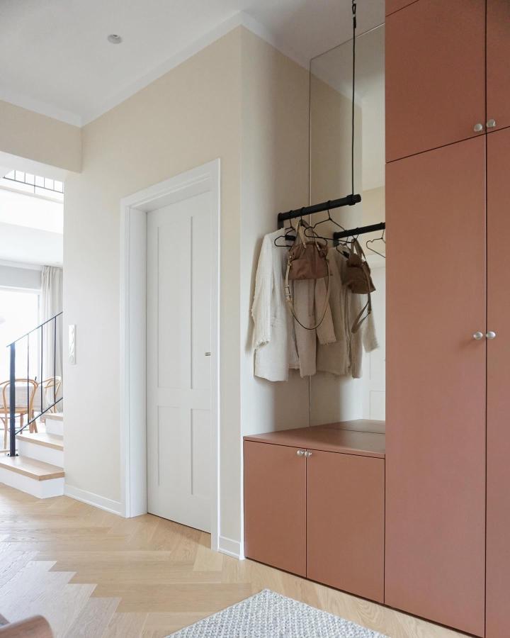 Warm terracotta Ikea Platsa wardrobe hack with matte finish and hanging rail in airy entryway from @hanghaus15. Cozy, modern storage solution.