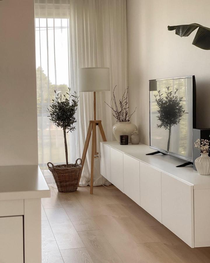 White minimalist ikea besta floating tv unit ideas from @marryss.home with natural wood lamp and woven basket planter creating a cozy modern living room vibe