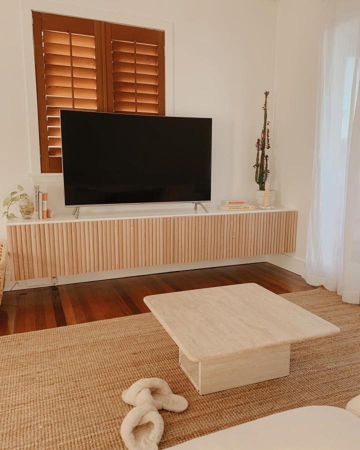 Light natural wood textured ikea besta floating tv unit ideas from @geebungalow with vertical slats and clean white base. Modern minimalist style.