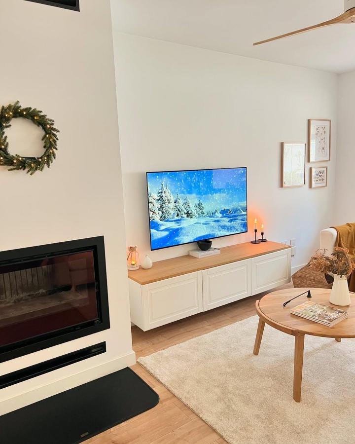 White floating Ikea Besta TV unit with wooden top and cozy styling from @lacasitadelporche in a bright living room.