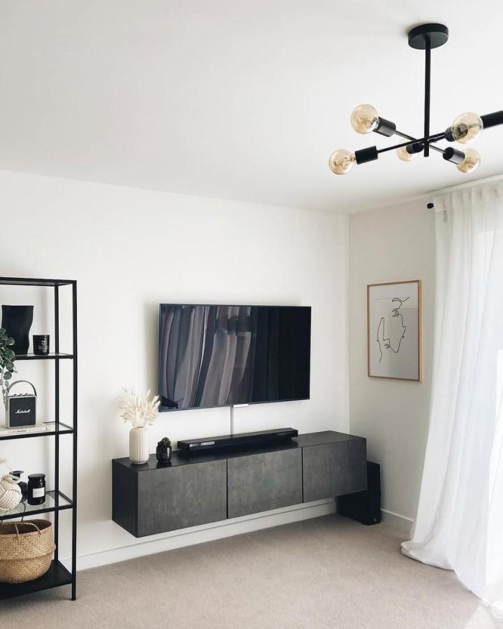 Dark grey concrete effect ikea besta floating tv unit ideas by @charlottebradbrook in minimal living room with black metal shelving and modern lighting.