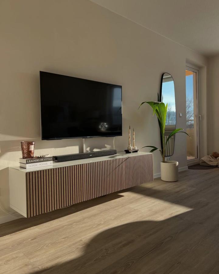 White and natural wood slatted ikea besta floating tv unit ideas from @homelybymi in bright living room with modern decor and plant.