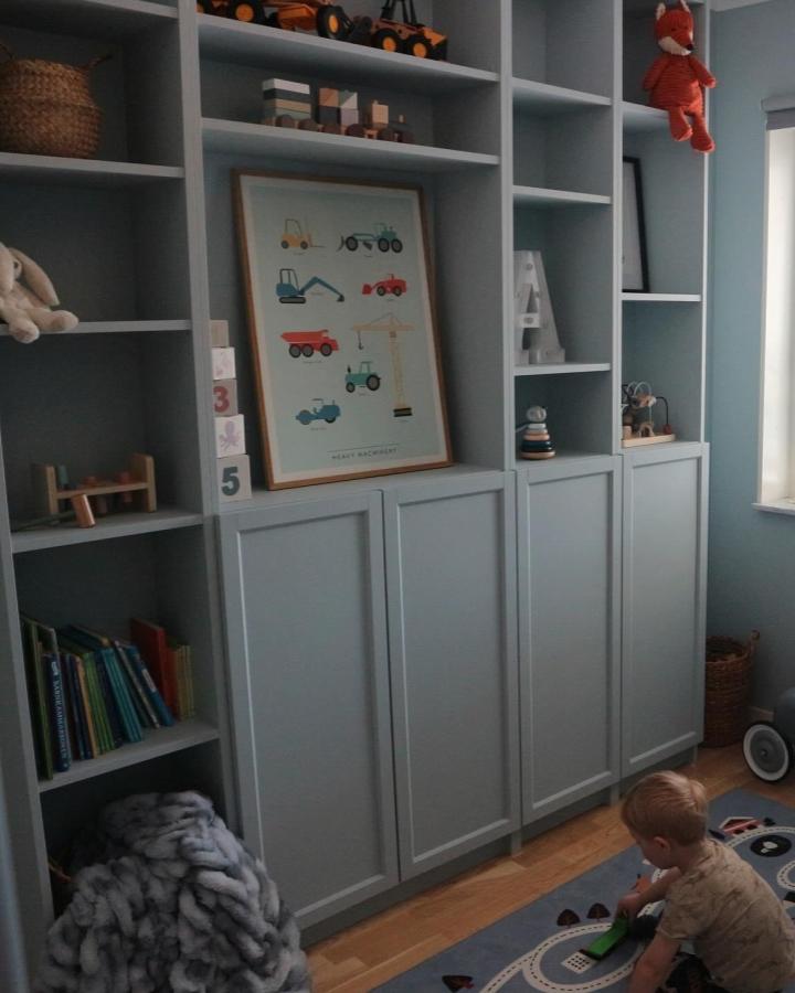 Blue painted Ikea Billy Oxberg bookcase idea from @kuttergatan with Oxberg cabinet doors and open shelves in a child's room.