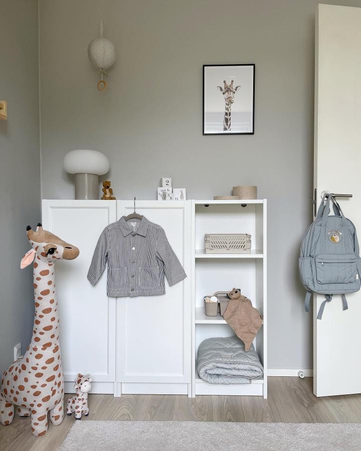 White Billy Oxberg unit with doors and shelves in a calm kids room by @annekkristensen. Soft gray walls and minimal decor complement the setup.