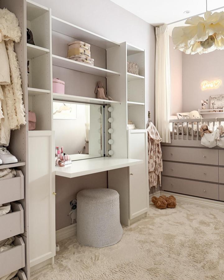 White built-in vanity with seven storage shelves and cushioned stool in soft pastel nursery room by @iidajj bright and cozy setup