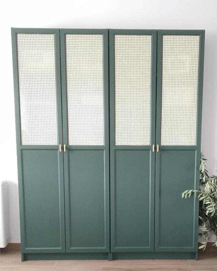Muted teal-green Billy Oxberg bookcase with cane panel doors and brass handles by @kelevoyahacer. Stylish and airy makeover.