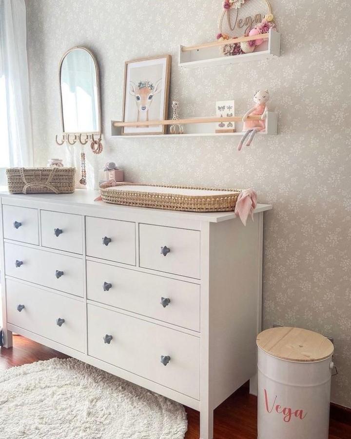 white Hemnes dresser with gray heart knobs and woven baskets in ikea hemnes nursery ideas by @inspiratievoorjebabykamer. Soft floral wallpaper and cozy natural accents.