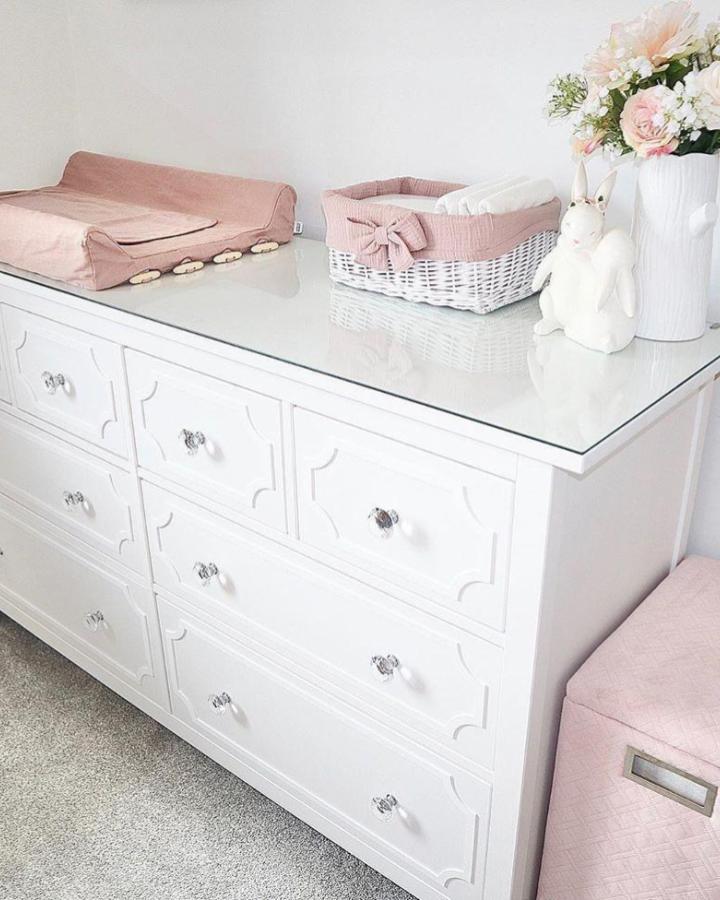 White Ikea Hemnes dresser with glass top, pink fabric accents and decorative details from @myoverlays for ikea hemnes nursery ideas. Chic and soft nursery style.