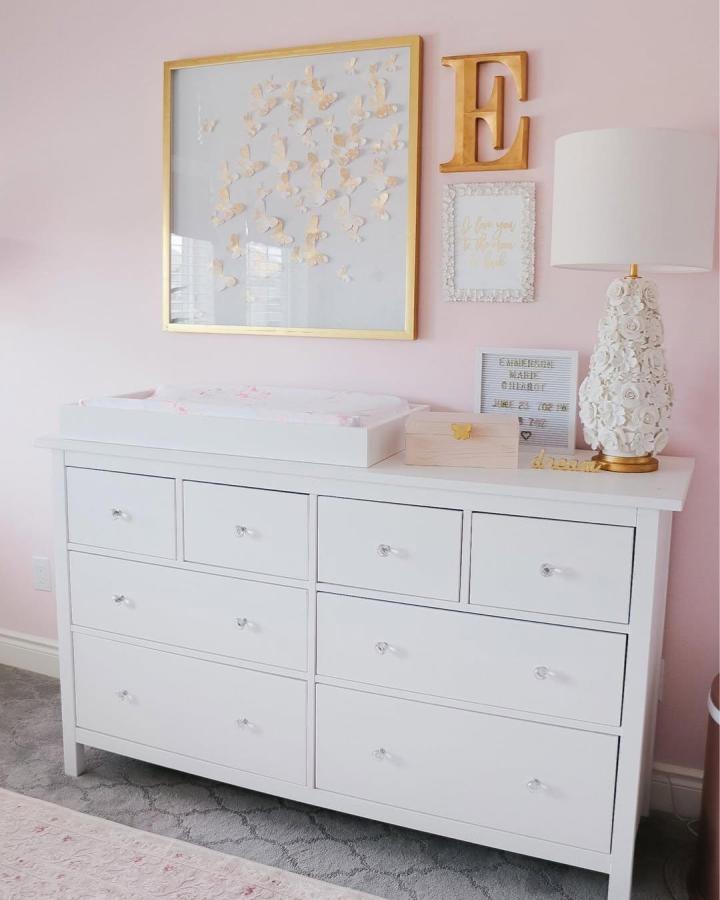 white dresser with gold and pink nursery decor from @jacquelinechiarotlifestyle ikea hemnes nursery ideas soft and elegant baby room setup