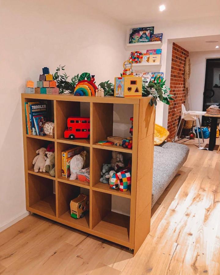 Natural wood ikea kallax toy storage ideas with colorful toys and greenery from @sophielouise.xxo in a cozy living space.