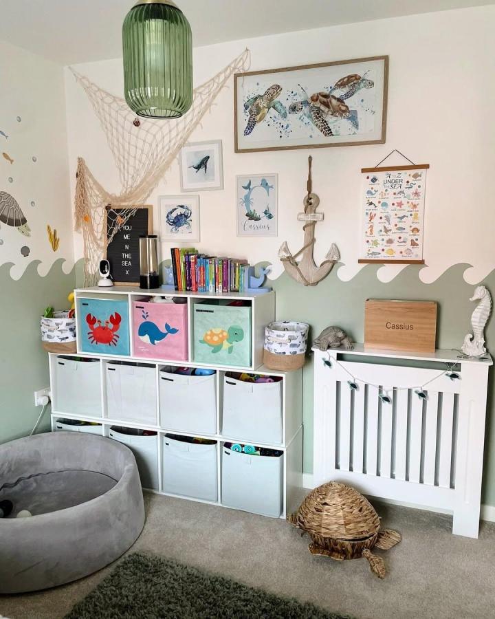 Green and white Kallax toy storage unit with colorful sea creature bins and ocean-themed decor by @homeattheolivers in a kids room.