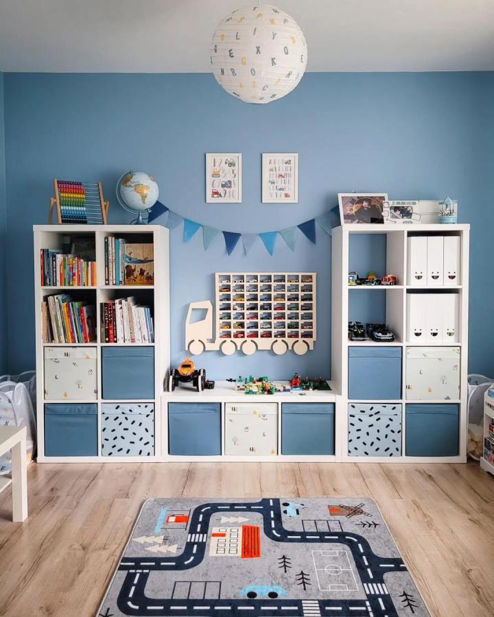 Blue and white Kallax shelving with four blue fabric bins and playful patterned storage boxes in kids room by @mrsfanaberia. Organized and stylish toy storage setup.
