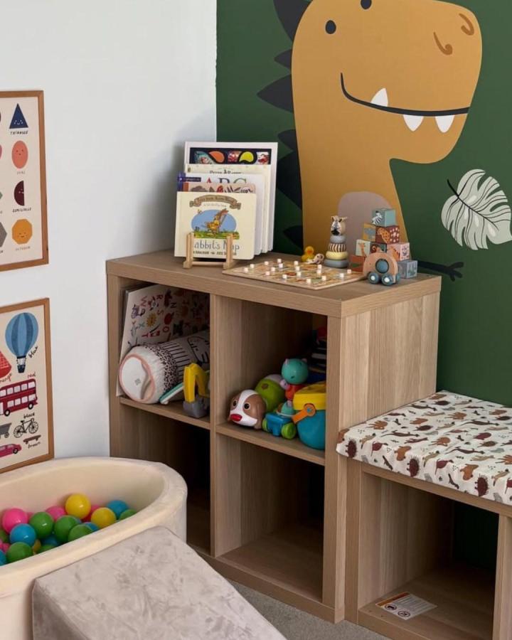 Natural wood Kallax storage with 17 compartments by @worn.bynavy for ikea kallax toy storage ideas in a kids playroom with cushioned bench and toys.