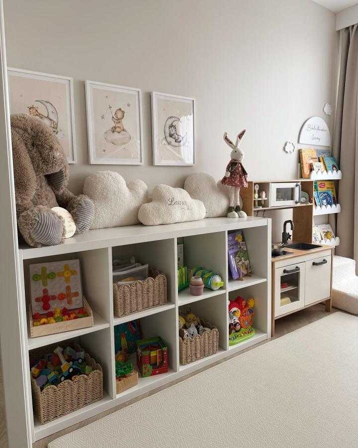 Neutral Ikea Kallax shelf with woven baskets and plush cloud pillows in a calm kids playroom by @nataliaxlaurka for stylish toy organization