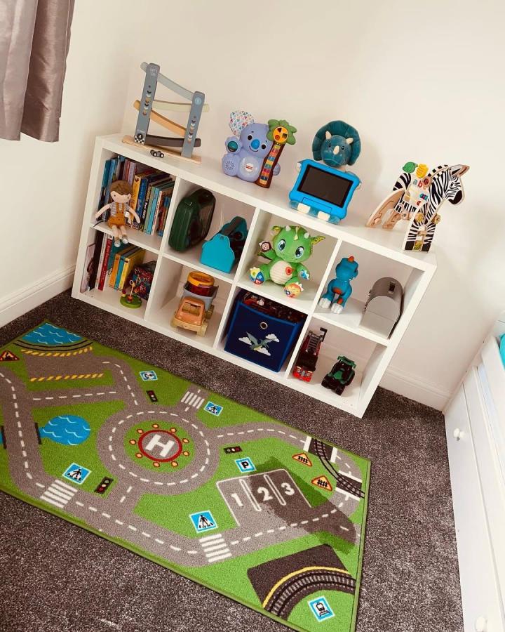 White Ikea Kallax toy storage unit with colorful toys and bins in a kid's room by @the_narburghhome, ikea kallax toy storage ideas.
