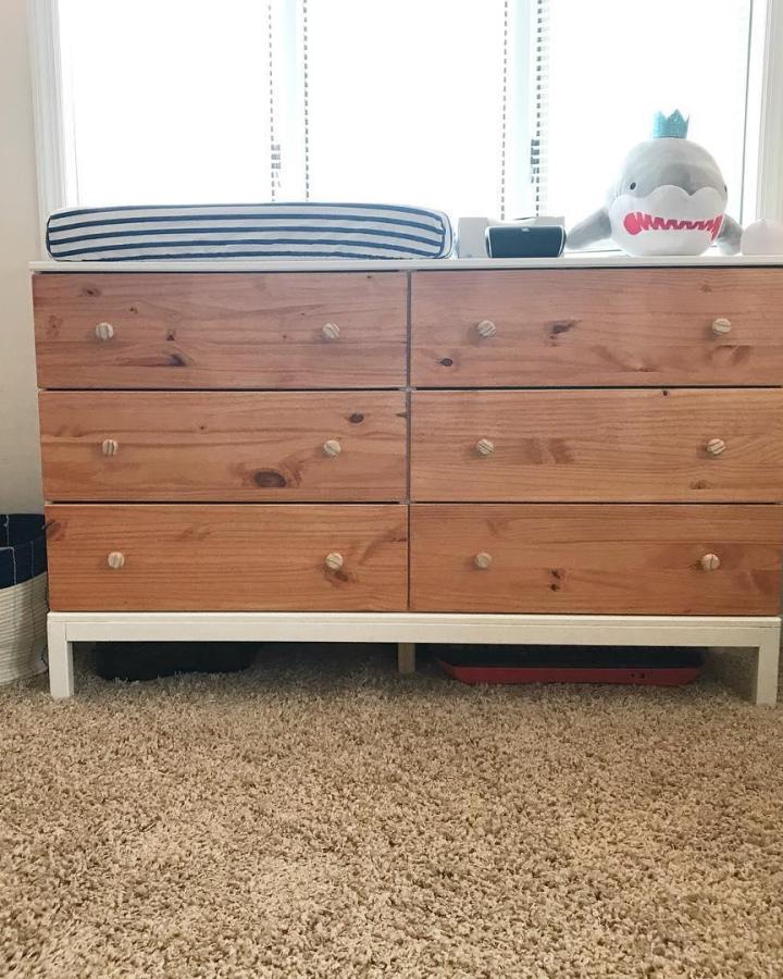 Natural wood Ikea Tarva dresser in nursery with white base and striped changing pad by @ohheybabycakess. Simple knobs and cozy vibe.
