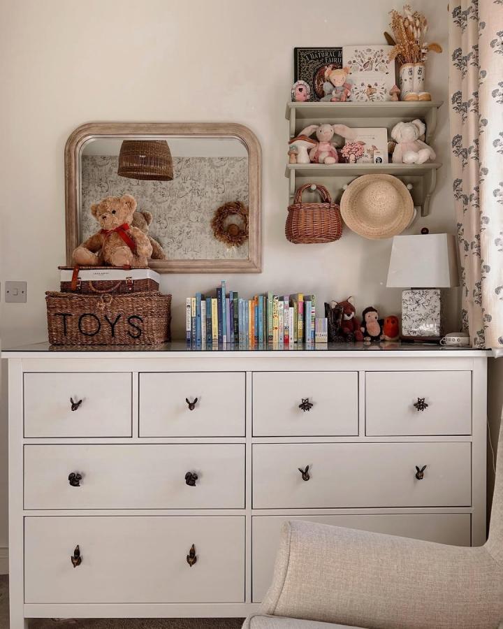 White Hemnes dresser with rustic drawer knobs and wicker baskets in a neutral nursery room by @devonhomelife. Cozy and charming storage setup.