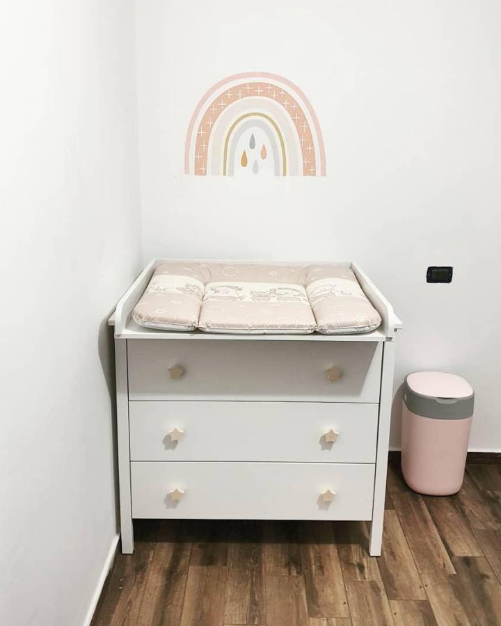 White Ikea Koppang nursery dresser with star-shaped knobs and a padded changing mat by @_queenhome_ in a cozy minimalist nursery setting. ikea nursery dresser ideas