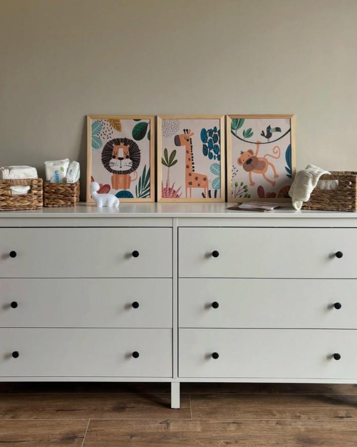 White Ikea Koppang dresser in nursery with playful framed animal prints and woven baskets from @nasz.dom.w.dipladeniach.3, cozy and functional style.