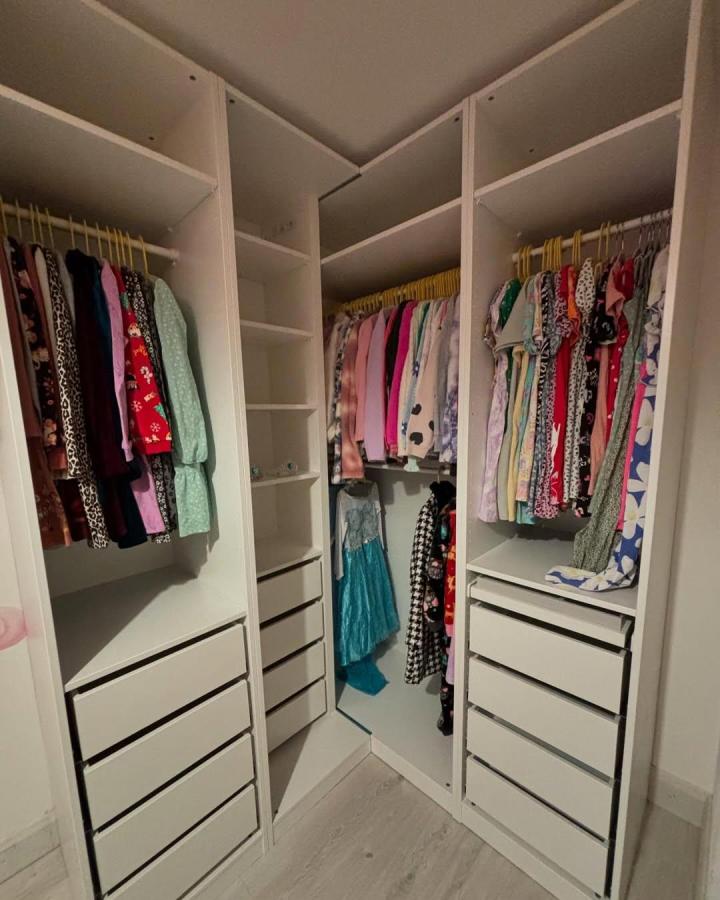 White Ikea Pax dressing room ideas with yellow rails and custom corner shelves from @southwest.selfbuild. Bright organized closet with drawers and hanging space.