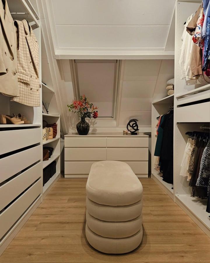 beige sculpted ottoman in white Ikea PAX dressing room with oak floors and minimalist accents from @interior.by.ml. Cozy and sleek ikea pax dressing room ideas.