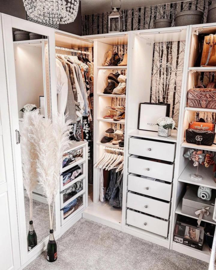 Bright white Ikea Pax dressing room ideas with built-in LED lights and stylish open shelves from @eltoria. Chic and functional storage.