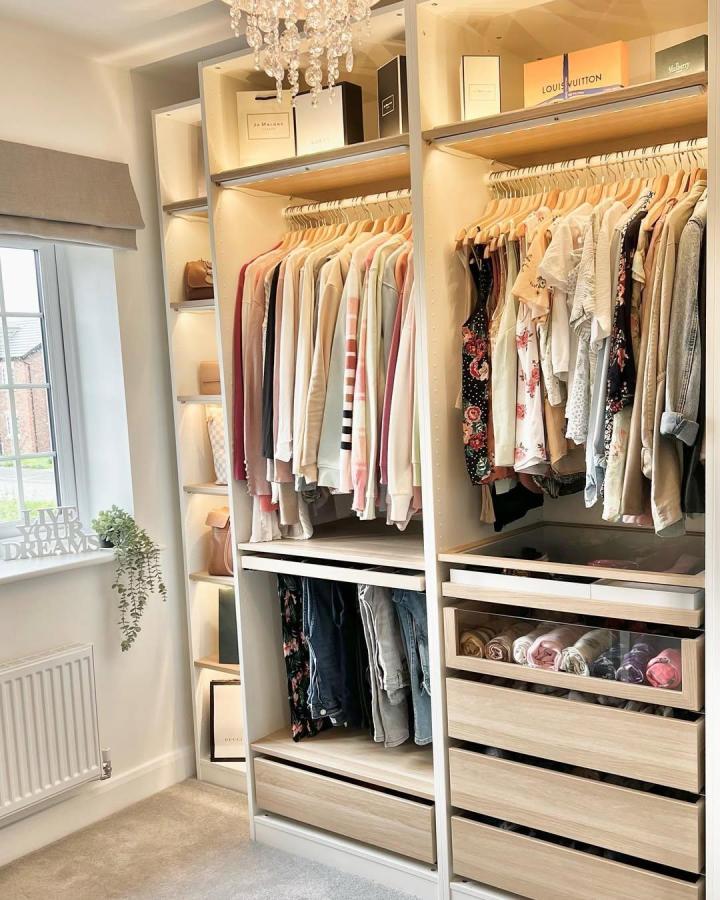 Soft beech wood Ikea Pax dressing room with glass drawers and warm lighting from @inside_our_nightingale_home. Cozy and organized space.