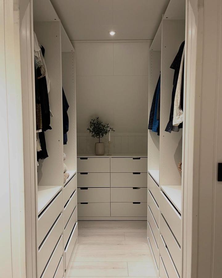 bright white ikea pax dressing room ideas with drawers and shelves from @homebykaroline neatly organized minimalist space with soft wood floor and plant centerpiece
