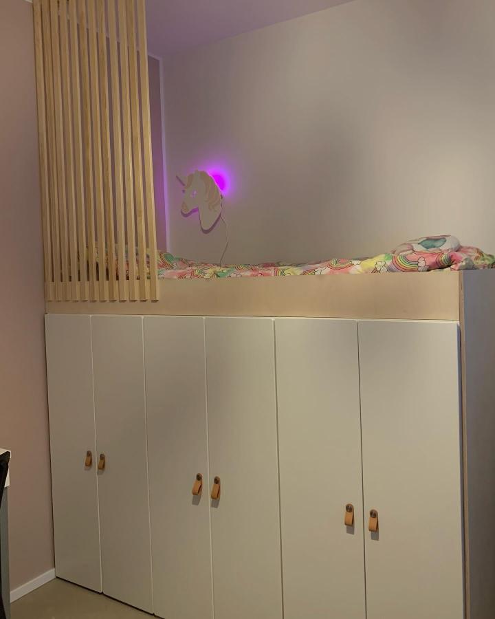 White minimalist storage unit with wooden handles and loft bed from @villa_vdp. ikea platsa kids room ideas with playful lighting and Scandinavian wood detail.