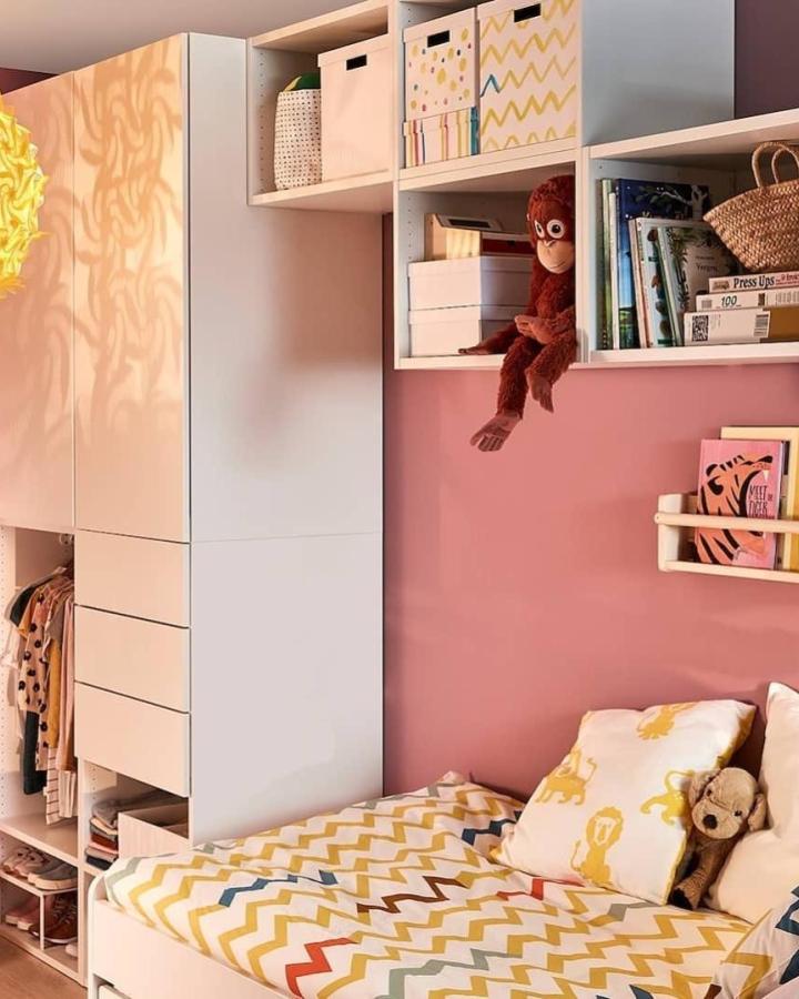 White modular Ikea Platsa storage with fabric bins and colorful zigzag bedding in a pink kids room by @home_land.ukraine showing ikea platsa kids room ideas.