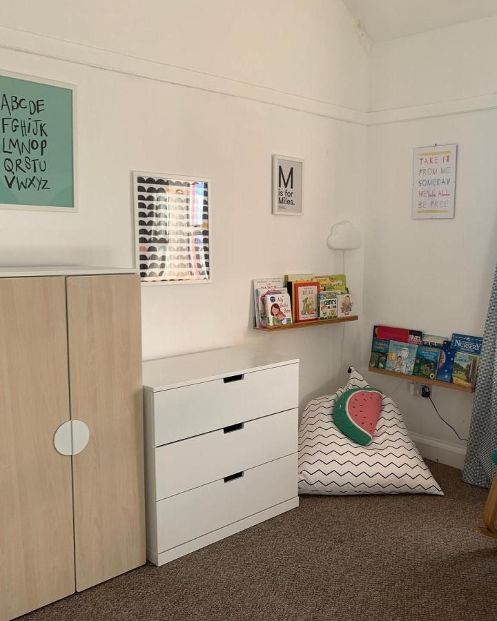 Light wood and white Platsa furniture in a child’s room with patterned bean bag and floating book shelves from @who_knowes_house. Cozy reading and storage setup.