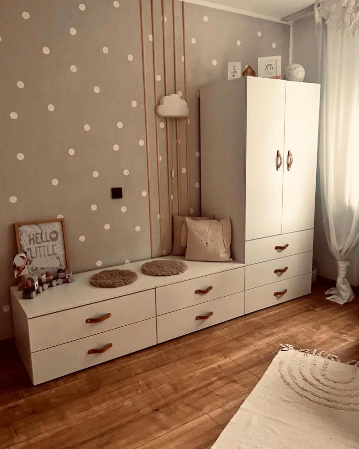 Creamy white modular storage with leather handles in a child’s bedroom by @gemuetlichgestaltet. Cozy and tidy space with soft polka dot wall and cushions.