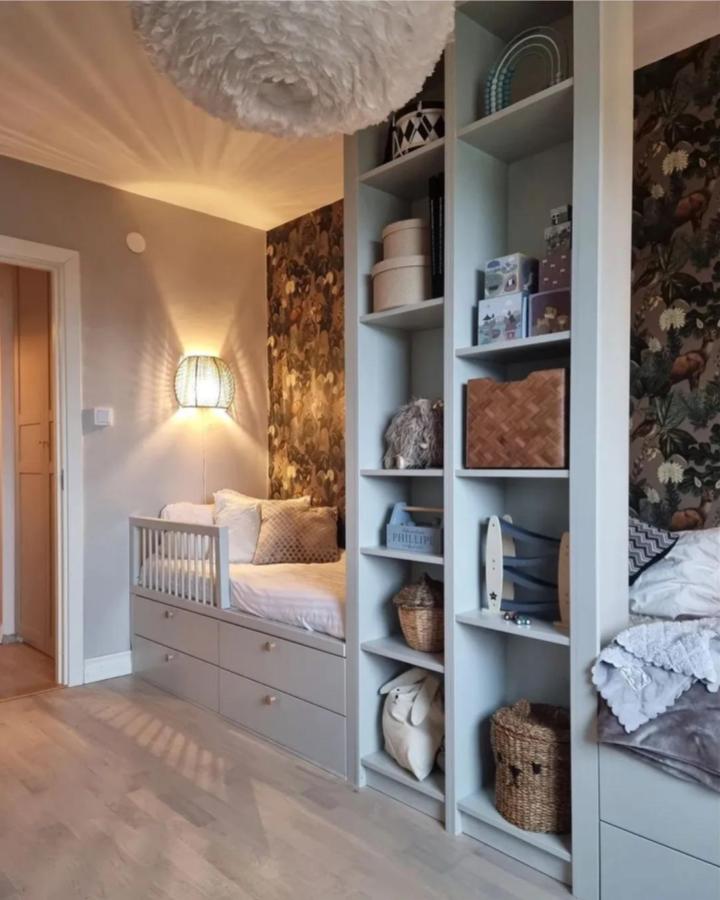 Light grey Platsa shelving and bed combo in kids room with baskets and floral wallpaper by @greidesign showcasing ikea platsa kids room ideas.
