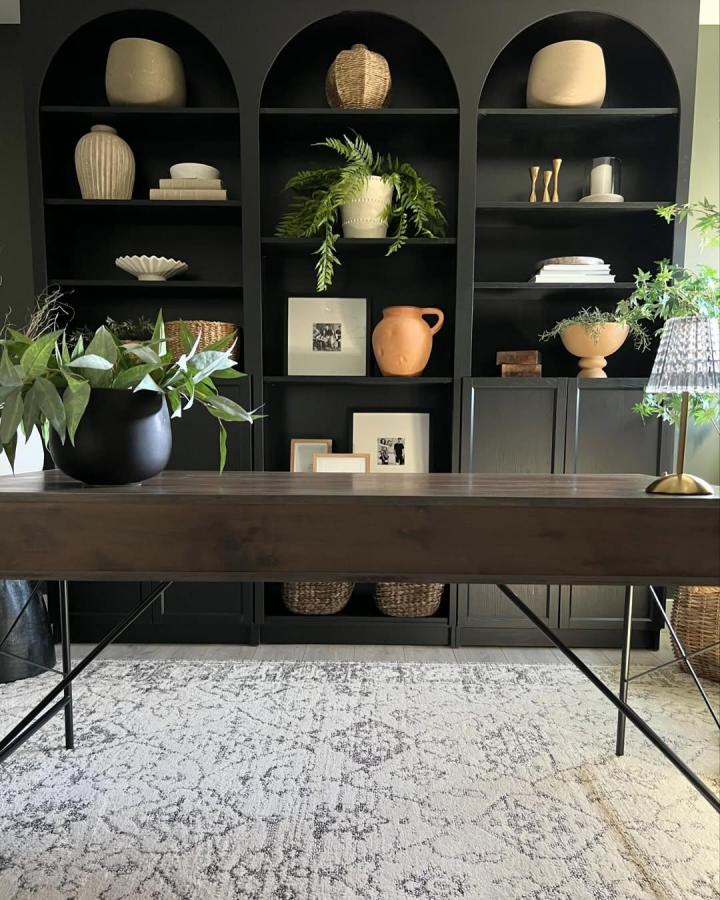Black matte arched built in shelving with ceramics and plants from @hemmainteriors_ Modern, sophisticated storage and display solution.