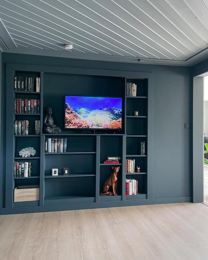 Matte blue built-in Billy bookcase media wall by @landligdraum with TV and decorative objects showcasing ikea billy bookcase media wall ideas.