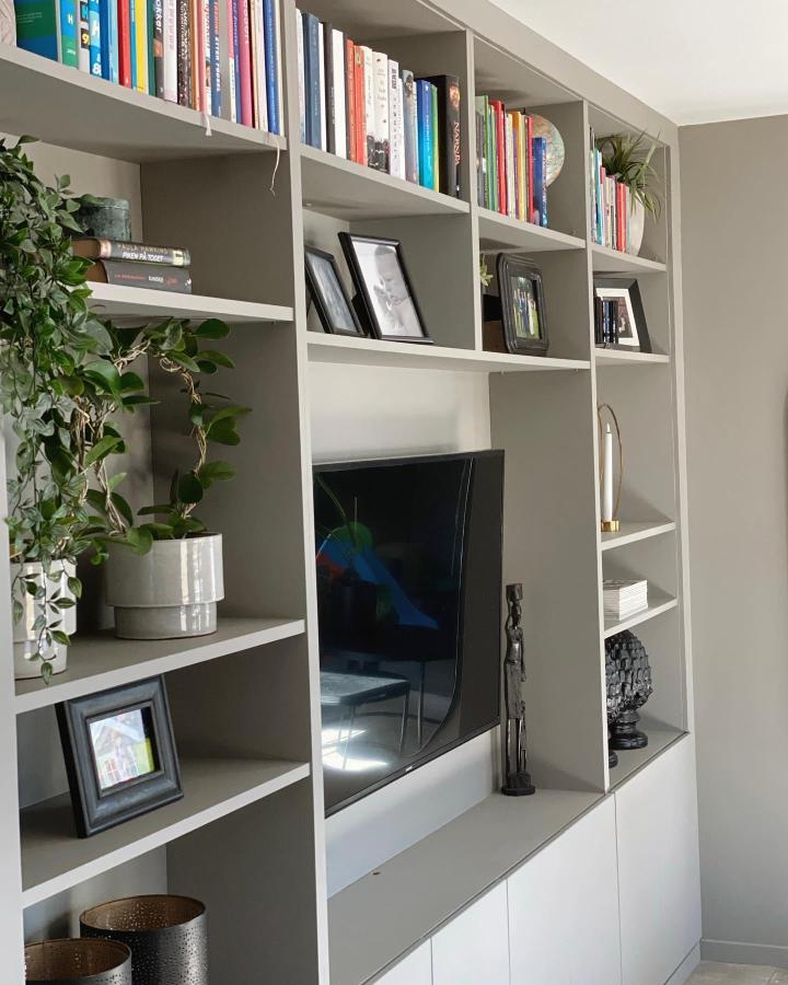 Matte gray built-in shelving with TV space from @troffelkroken featuring books and decor creating a calm living room vibe