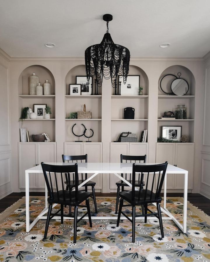 Beige painted built-in Billy bookcases with arched backs by @firsthouseonfinn styled with baskets and black ceramics showcasing ikea billy bookcase styling.