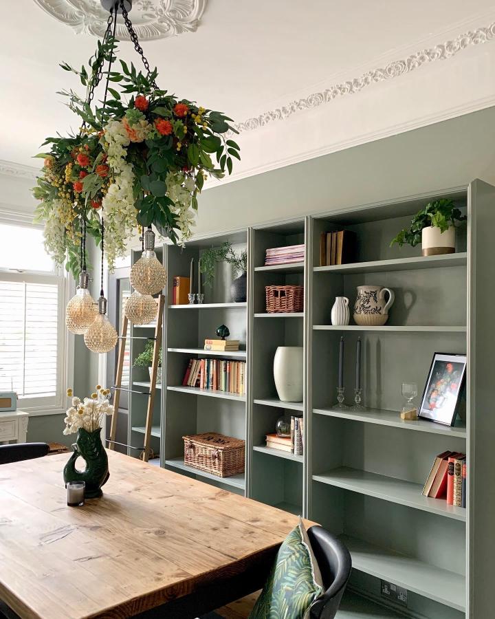Soft green painted bookcases in dining room styled by @welcome_to_no.1 with ceramics, books, baskets, and greenery creating a warm, classic look