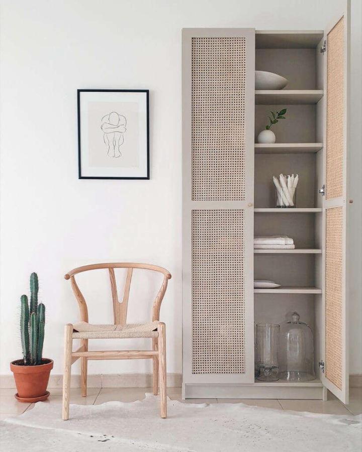 Woven cane door Ikea billy bookcase styling by @stylethishouse in neutral gray with natural textures and open shelves.