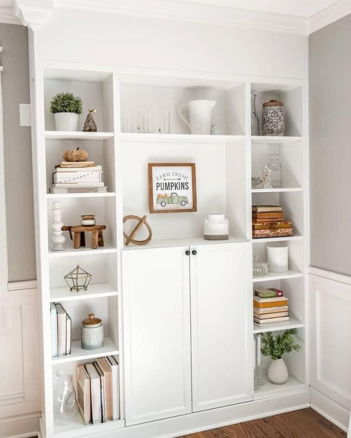 White minimalist bookcase with cabinet doors from @theappelofmyeyediy showing stylish concealed storage and open shelving design.