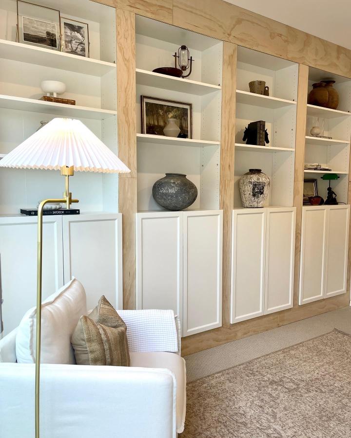 White and natural plywood built-in shelves by @myprovincialhome with custom flat panel cabinet doors and eclectic decorative pieces.