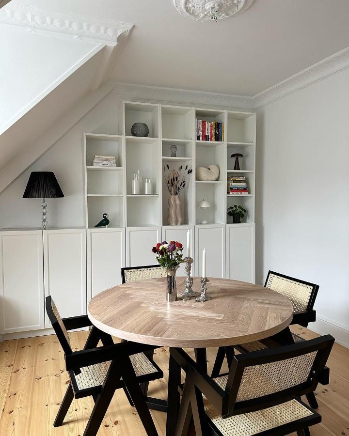 White modular shelving with custom cabinet doors in a Scandinavian dining room by @ceciliedraebye. Minimalist design with a mix of open and closed storage.